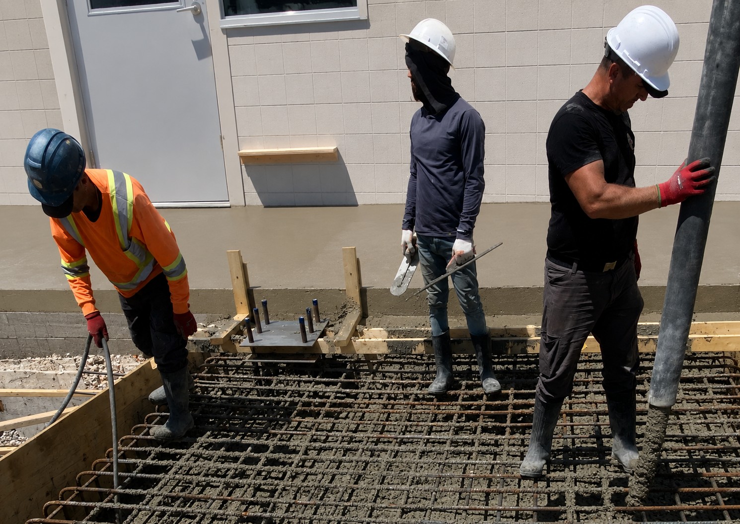 Crew pumping concrete into reinforced work